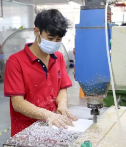 A technician polishing acrylic components with specialized equipment